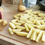 Halbierte Kartoffelspalten auf Backblech